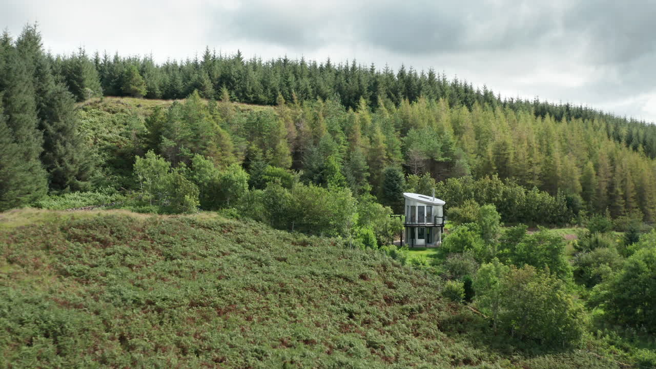 공중 설치 - 현대적인 알루미늄 주택이 숲 속에 자리 잡고 있습니다.