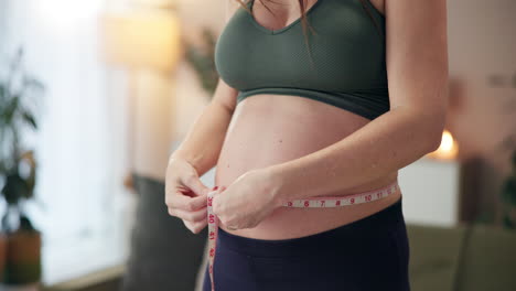 pregnant woman measuring her belly