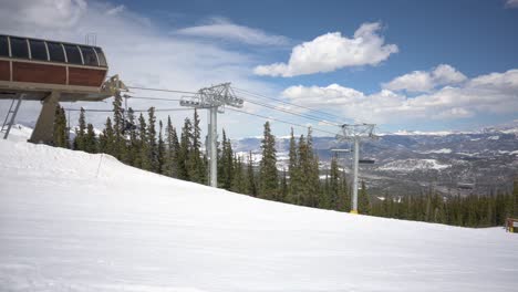 Skilift-An-Der-Spitze-Einer-Skipiste,-Der-Tagsüber-Skifahrer-Und-Snowboarder-Mit-Wolken-Befördert