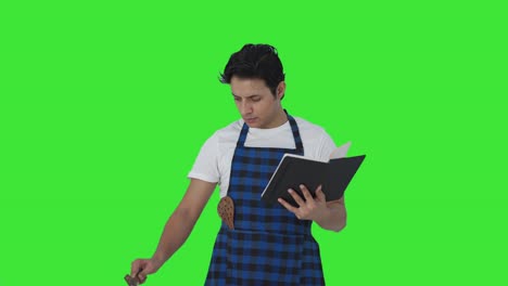 cocinero indio serio haciendo comida de libro de recetas pantalla verde