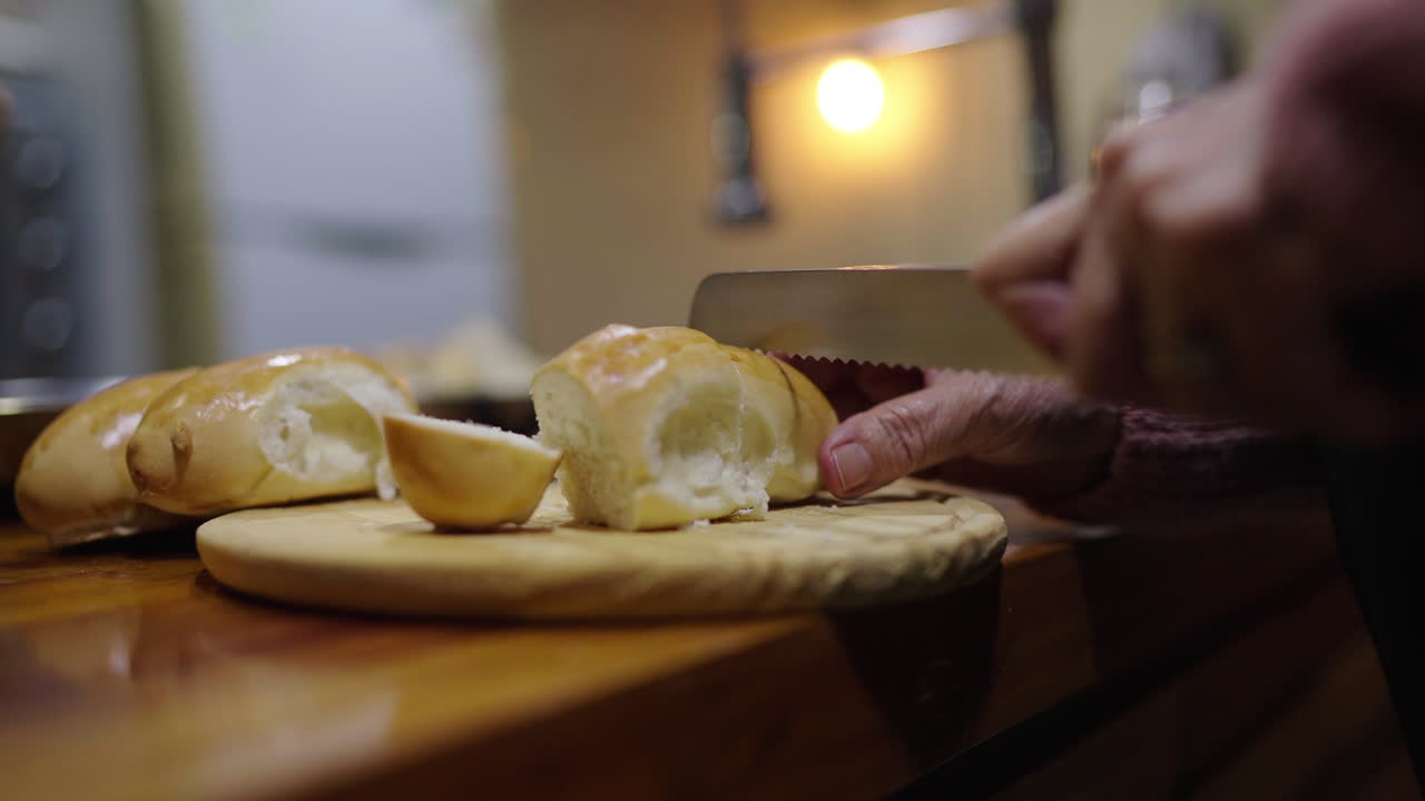 Slicing fresh white bread at home as part of preparing ingredients for Bagna Cauda