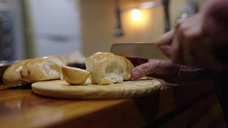 slicing fresh white bread at home as part of preparing ingredients for bagna cauda
