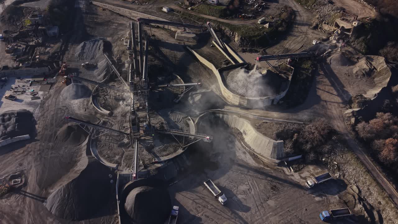 Mining operations at a quarry with trucks and machinery in motion