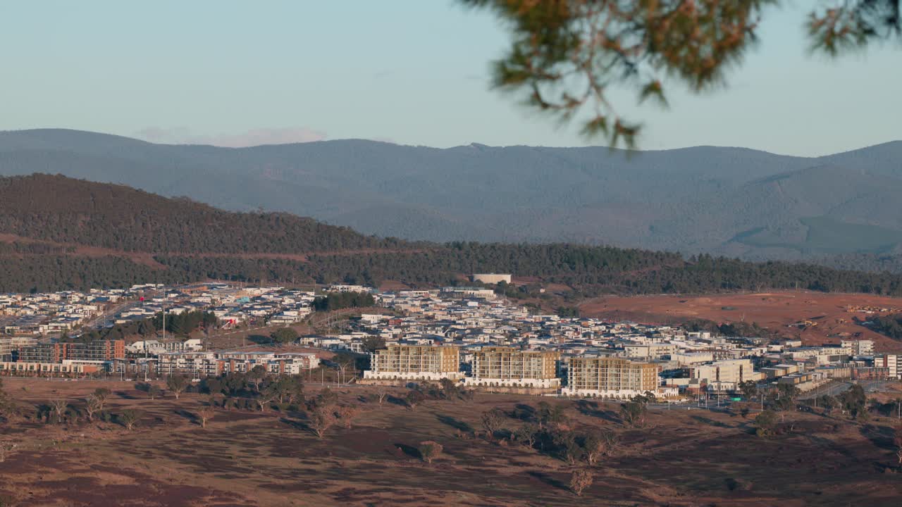 The suburb of Denman Prospect sits below the towering Brindabella mountain range during a calm golden morning