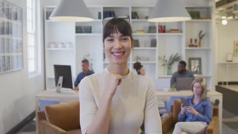 Mujer-Joven-Sonriendo-A-La-Cámara-En-La-Oficina.