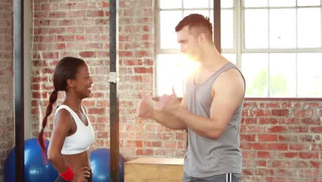 pareja en forma de dar los cinco en el gimnasio de crossfit