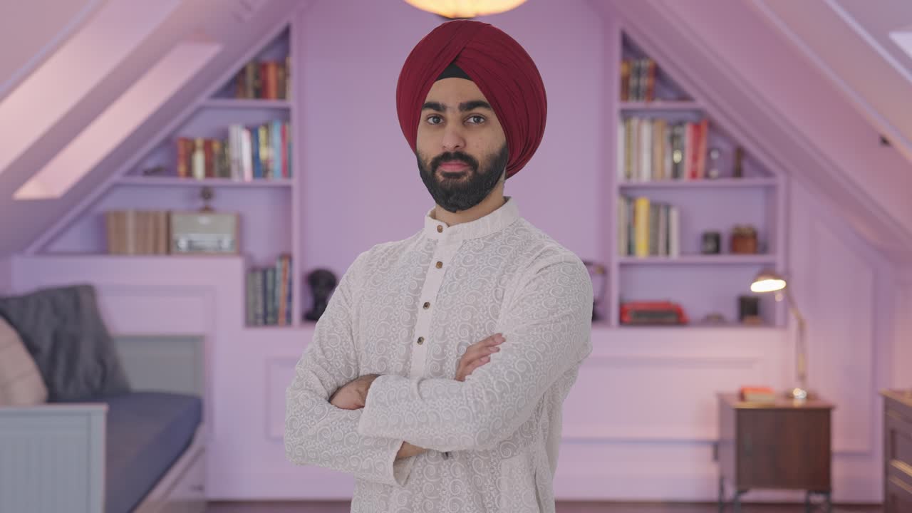 Ritratto di uomo indiano Sikh fiducioso in piedi con le braccia incrociate