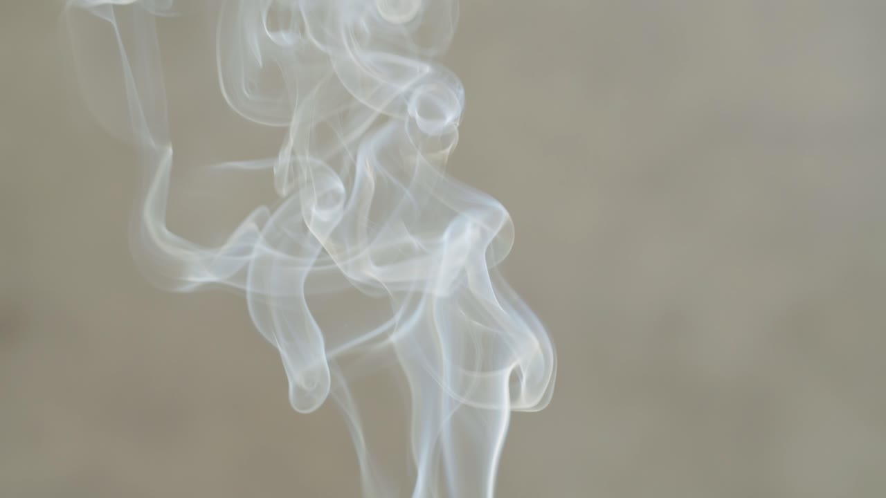 Person holding Palo Santo wood stick in hand, aromatic Palo Santo burning on black background, smoke spreading around, slow motion video clip, high quality 4k close up footage. High quality 4k footage