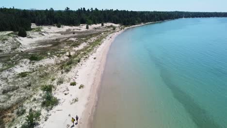aerial two walking on beach - fisherman island, michigan