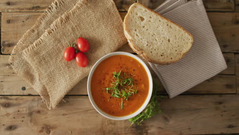 Vídeo-De-Sopa-De-Tomate-Crema-En-Un-Tazón-Sobre-Una-Mesa-De-Madera-Con-Pan