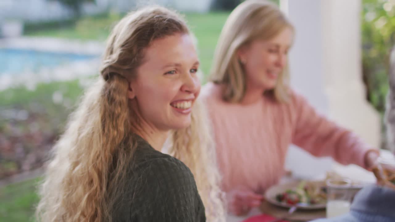 행복 한 백인 어머니 와 할머니 가 야외 가족 저녁 식사 테이블 에서 웃는 영상