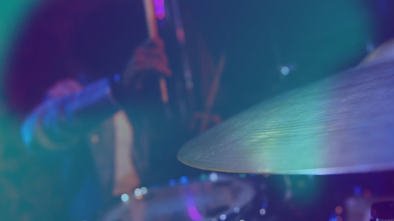 Batterista che colpisce un piatto con le bacchette per una pubblicità musicale, mostrando onde sonore animate che si alzano.