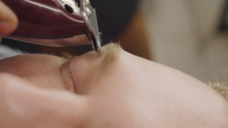 Close-Up-of-Shaving-Eyebrows-with-Trimmer