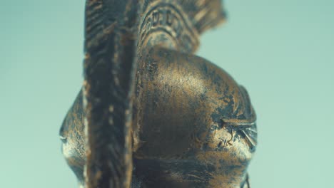 A-rotating-close-up-macro-shot-of-a-spartan-warrior-metal-bronze-ancient-greek-helmet,-with-shapes-and-forms-on-top,-studio-lighting,-slow-motion,-4K-video