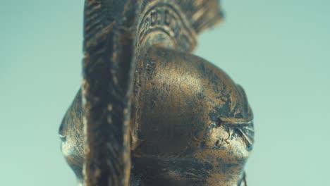 una toma macro giratoria de un casco griego antiguo de bronce de metal guerrero espartano, con formas y formas en la parte superior, iluminación de estudio, cámara lenta, video de 4k