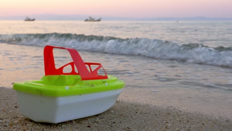 Barco-De-Juguete-De-Plástico-Junto-A-Las-Olas-Del-Mar