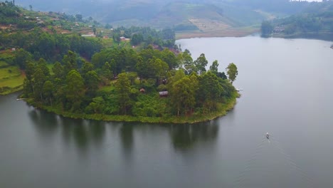 aerial over a motorboat longboat canoe traveling on a lake in a lush part of uganda africa