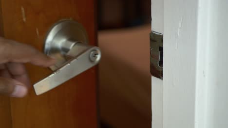 la mano del hombre abriendo la puerta de cerca