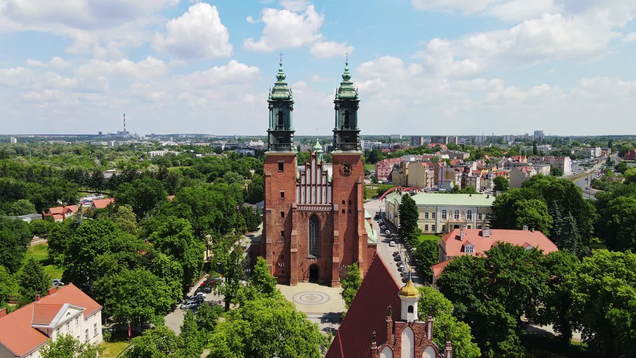 Poznań Cathedral rises majestically, greenery and historic city skyline, drone