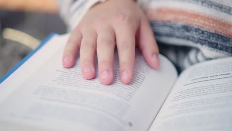 Close up of girl's fingers following lines she reads in a book