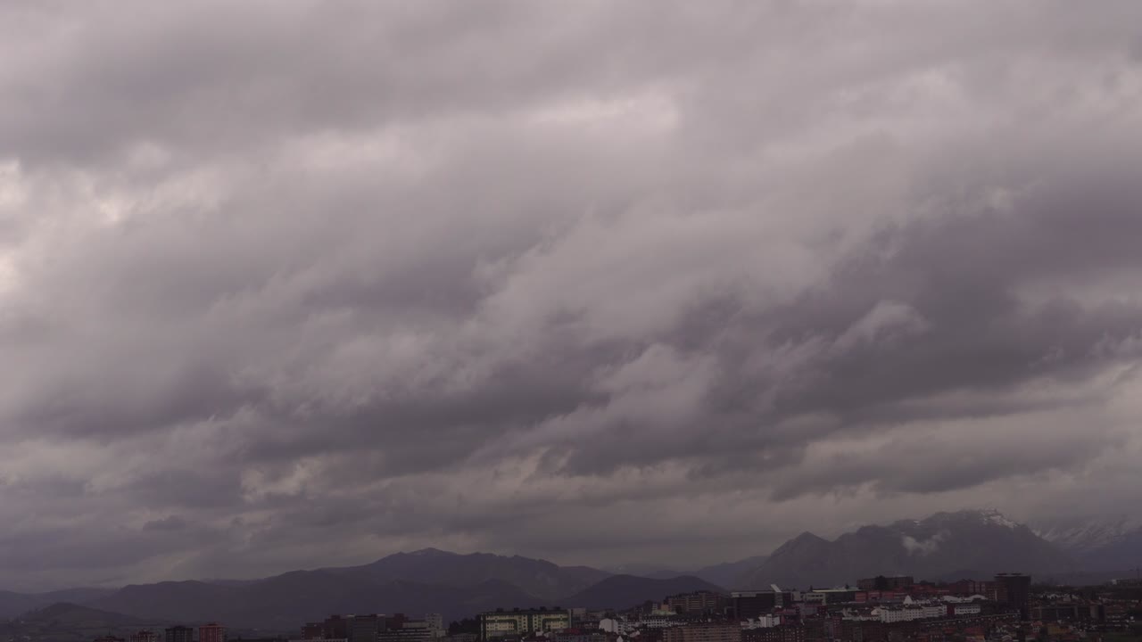 눈 인 산꼭대기 중의 비 구름이 도시에 다가오고 있습니다.
