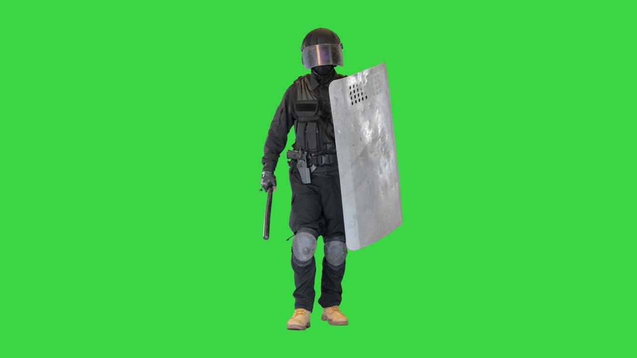 Riot policeman with a shield and baton walking on a Green Screen, Chroma Key