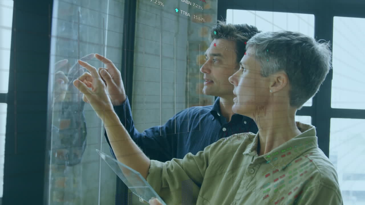 Animation of data processing over diverse man and woman discussing over glass board at office