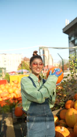 woman picking a pumpkin at a fall market