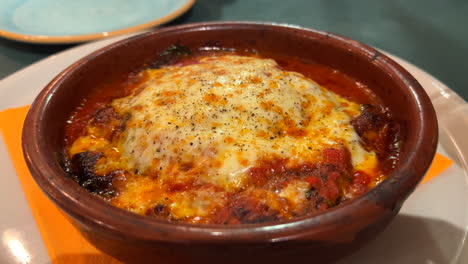 plato tradicional italiano de parmigiana de berenjena con queso derretido, tiro de 4k