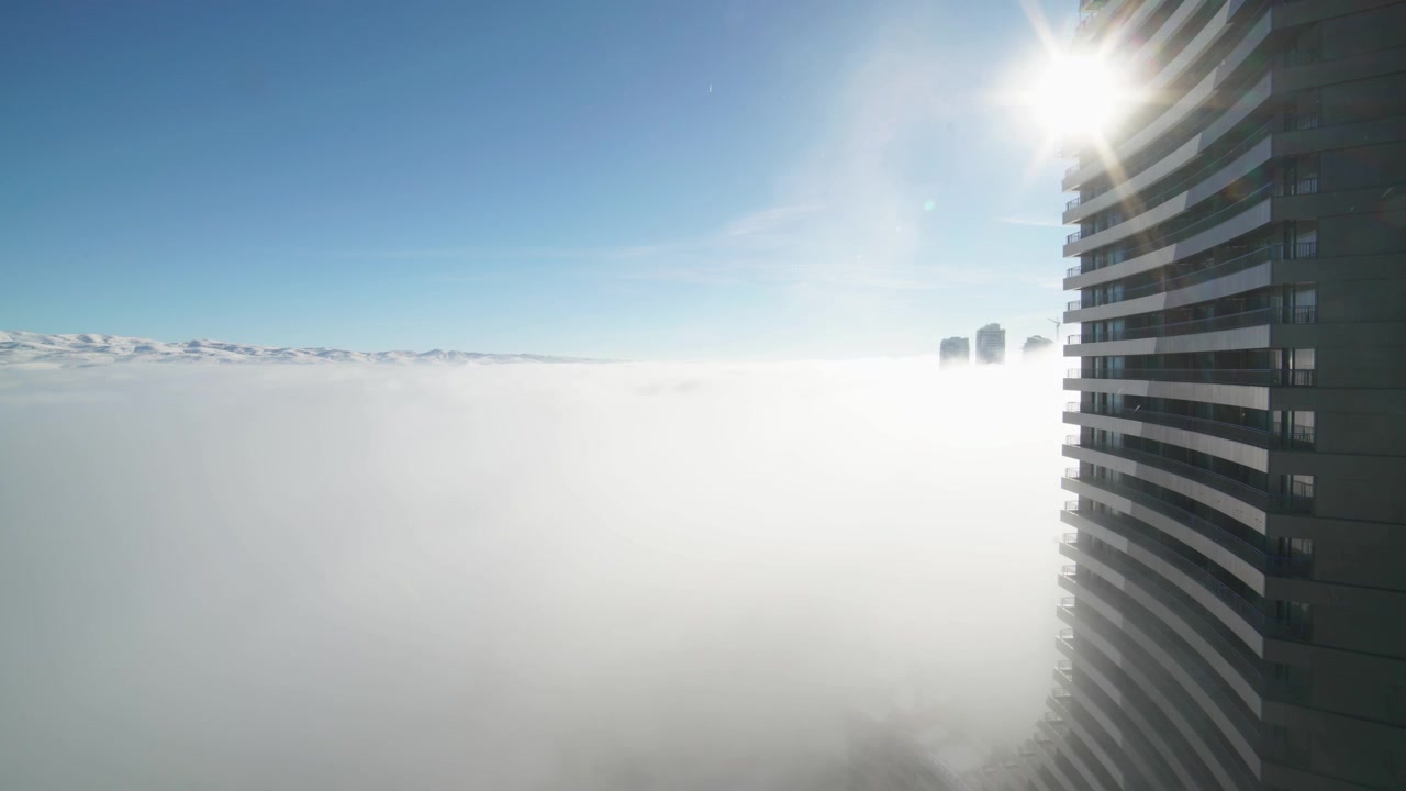 Grattacielo moderno sopra uno spesso strato di nebbia mattutina