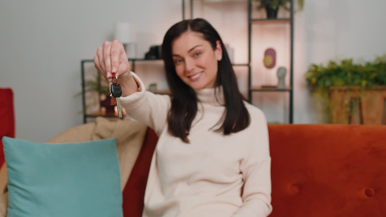 Woman real estate agent showing the keys of new home house apartment buying or renting property