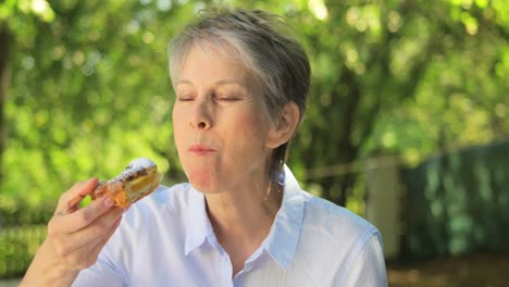 Mujer-Mayor-Comiendo-Comida-Dulce-En-El-Jardín