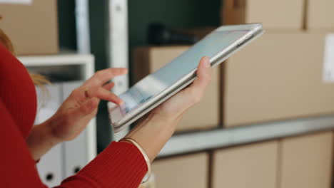 woman using tablet in warehouse with boxes