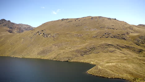 drone volando sobre las montañas de los andes y el lago en el parque nacional cajas, ecuador
