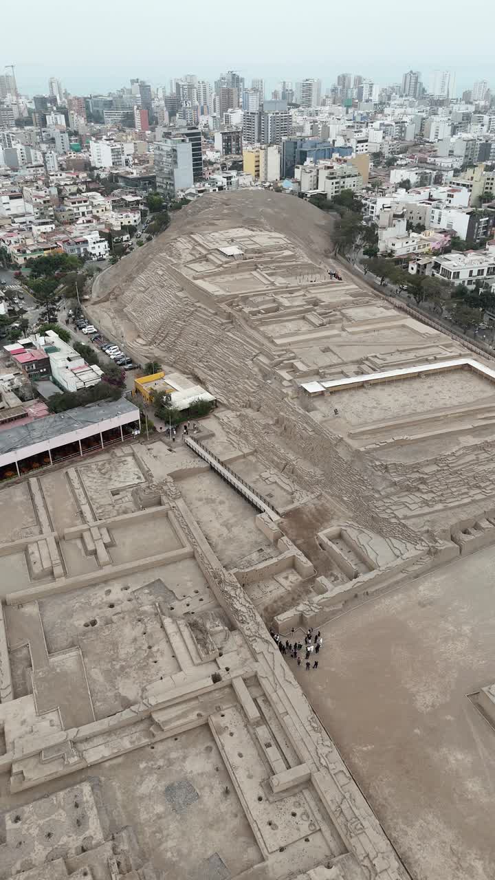 View of Huaca Pucllana pyramid ruins in the middle of a modern cityscape. Lima, Peru. Aerial vertical video
