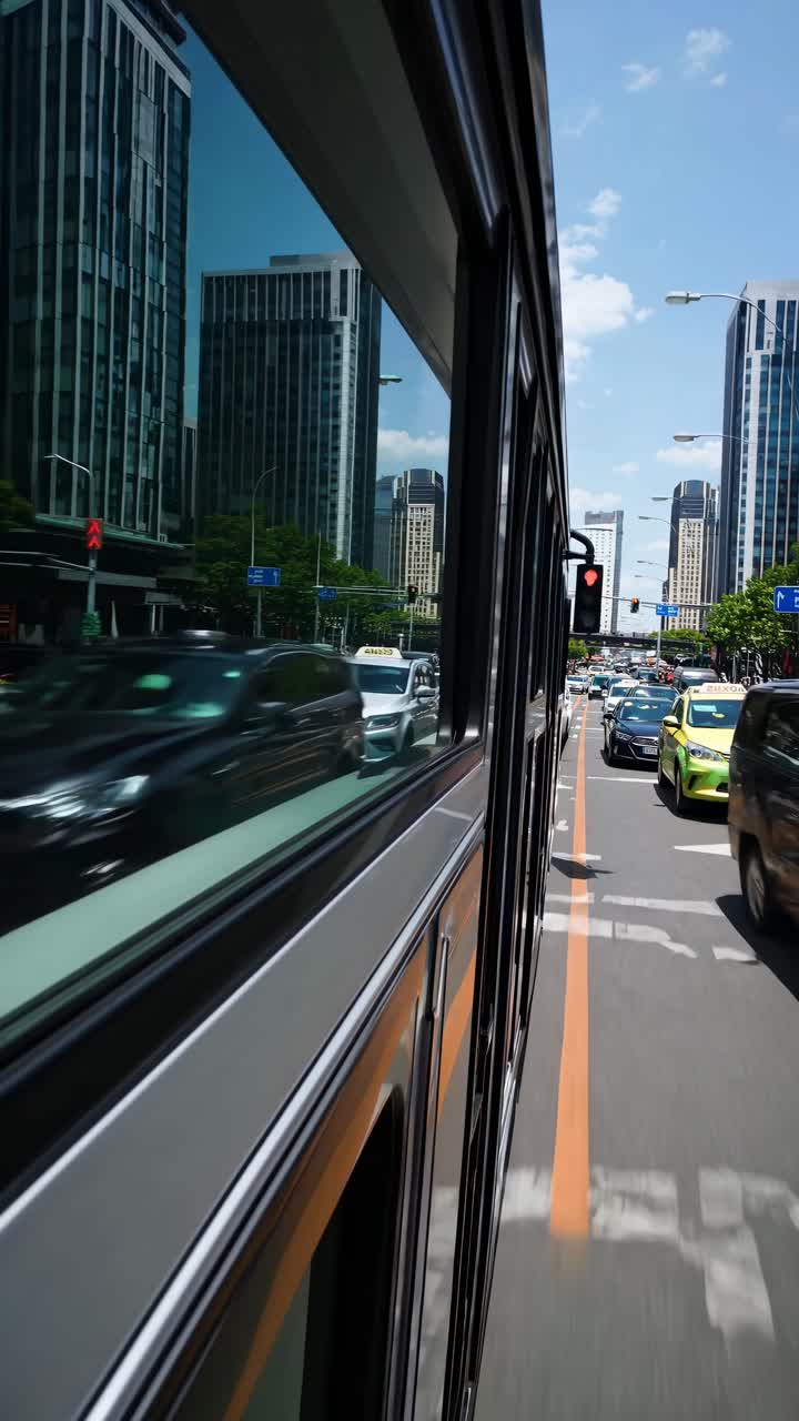 Dynamic side-angle video shot from a bus, capturing urban traffic and skyscrapers