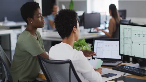 Two-diverse-businesswoman-working-together-on-laptop