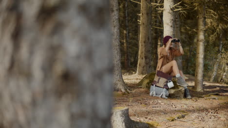 Mujer-Joven-Mirando-A-Través-De-Binoculares-En-El-Bosque.