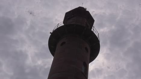 Stratus-clouds-blowing-high-over-lighthouse-silhouette-at-Pharos-Lighthouse,-Fleetwood,-Lancashire,-England,-UK