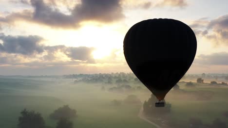 hot air balloon ride at sunrise over misty landscape