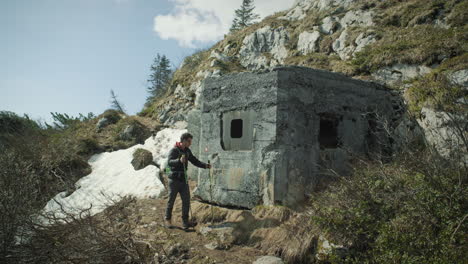 Hiker-stopping-at-the-concrete-fort-to-look-throuh-the-window