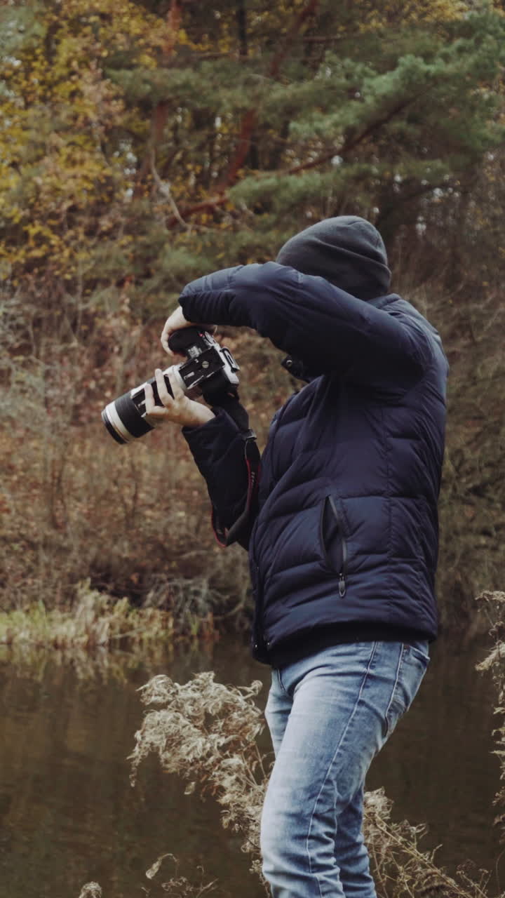 Man standing on shore. Aerial view of man standing on lake shore and taking photo of nature