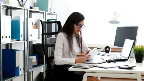 mujer de negocios hablando en teléfono inteligente y trabajando en una oficina moderna