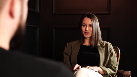 over shoulder view during indoor interview conversation between male and female