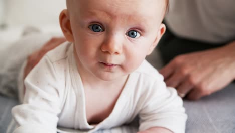 closeup of cute blue eyed baby trying to crawl