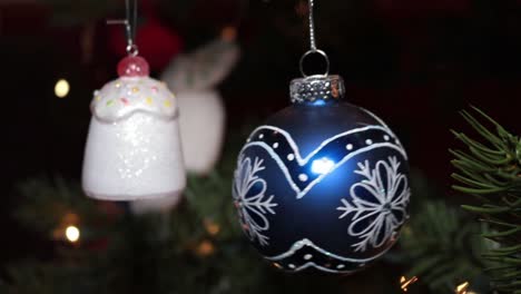 colgando un hermoso adorno en un árbol de navidad