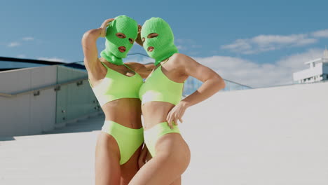 two women in lime green swimsuits and balaclavas