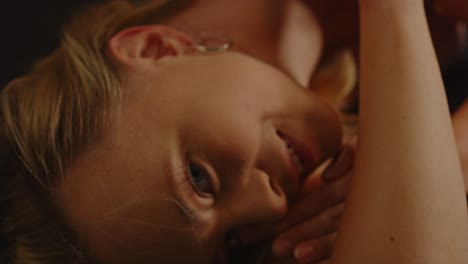 Close-up-of-a-beautiful-blond-woman-lying-down-and-seductively-looking-at-camera