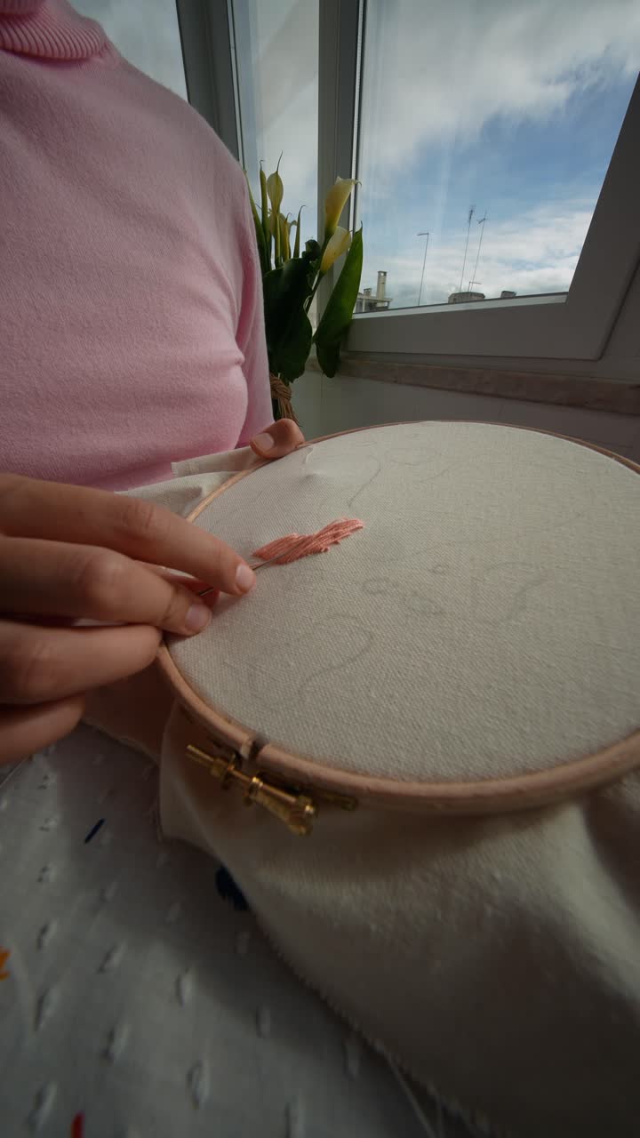Woman's Hands Doing Punch Needle Embroidery with Pink Yarn