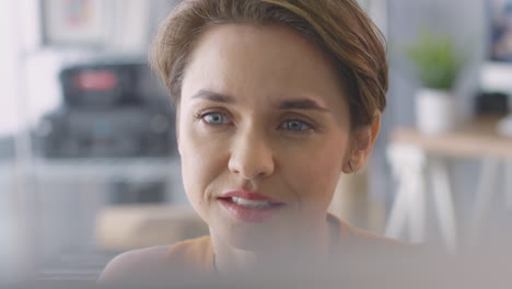 close up of female architect in office working on desktop computer viewed from behind screen